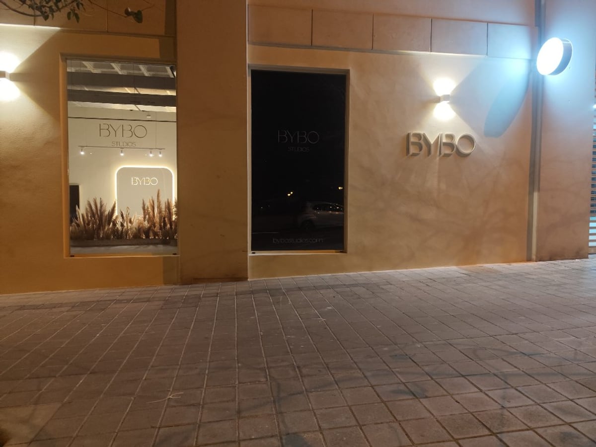 Fachada BYBO de noche con letras y banderola luminosa