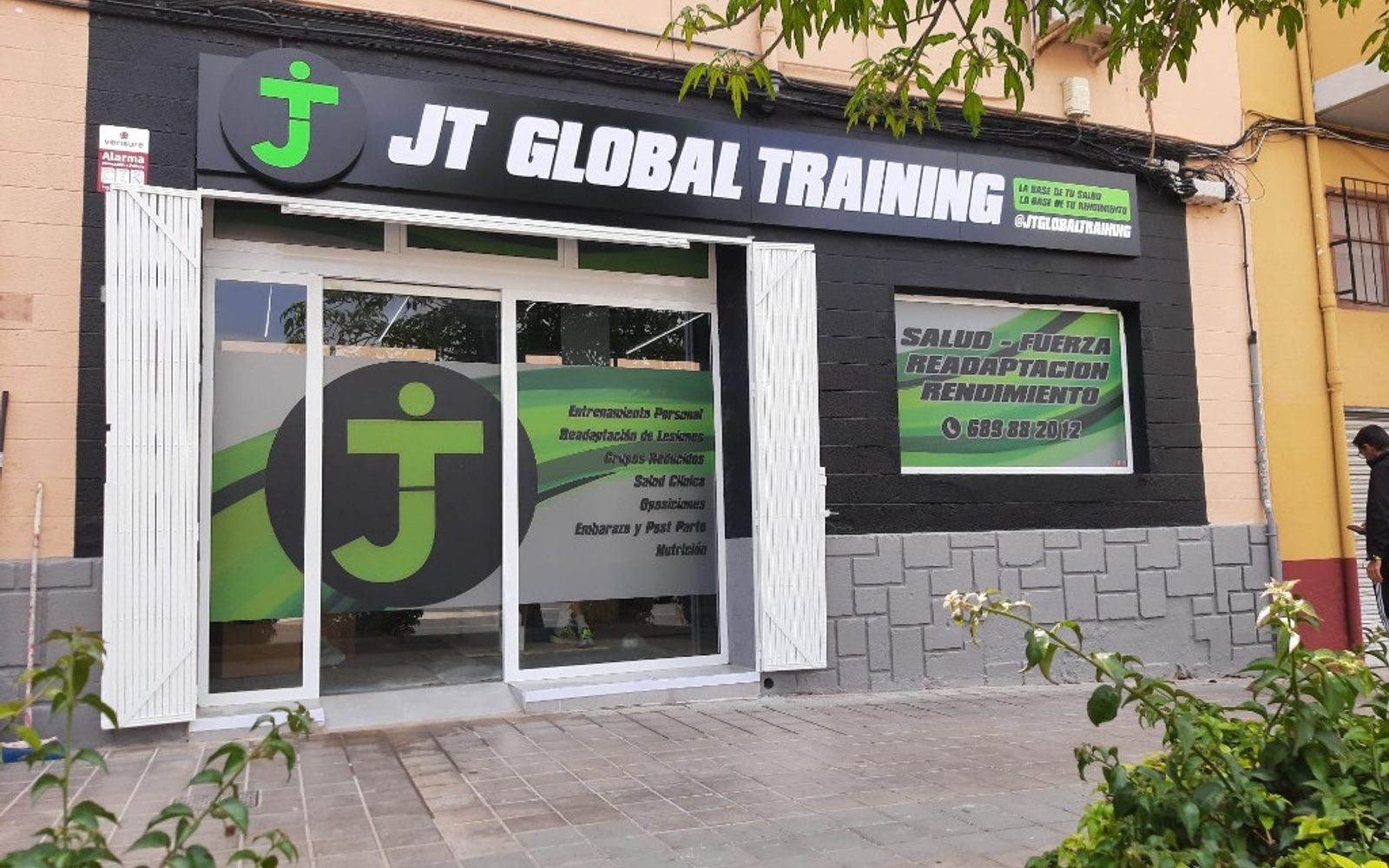 Fachada JT Global Training terminada con rótulo, vinilos y revestimiento negro